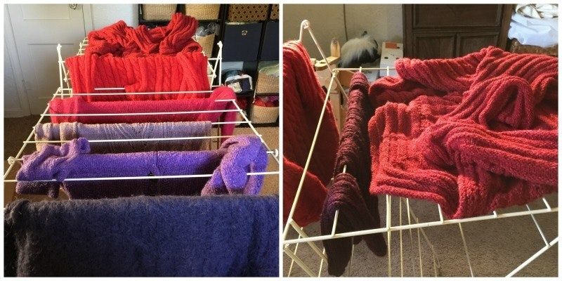 Ullplagg i rött, lila och mörkblått torkar plant på ställningar